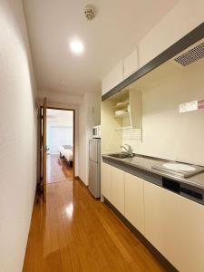 eine Küche mit Spüle und Kühlschrank in der Unterkunft Grandeur by b hotel - Cozy 1BR Near Peace Park Quiet & Central Stay in Hiroshima