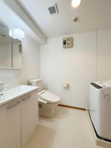 ein weißes Badezimmer mit Toilette und Waschbecken in der Unterkunft Grandeur by b hotel - Cozy 1BR Near Peace Park Quiet & Central Stay in Hiroshima