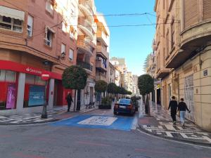 two people walking down a city street with buildings at Pizarro Apartment in Villajoyosa