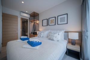 a bedroom with a large white bed with blue pillows at Lakeside Residences by NLA in Bang Tao Beach +44 photos