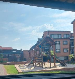 a playground with a slide in front of a building at Mordern Lil' Love Nest Loft in Midrand in Midrand +8 photos