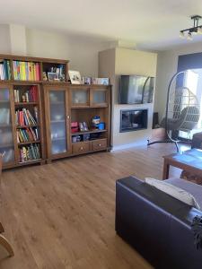 a living room with a couch and book shelves at Casa do alpendre in Ourense