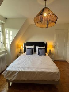 een slaapkamer met een groot wit bed met twee lampen bij Maison Hyper centre Dinan 2,4 ou 6 personnes in Dinan