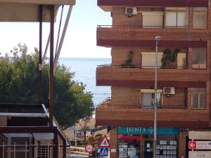 a tall brick building with a balcony on a street at Pizarro Apartment in Villajoyosa