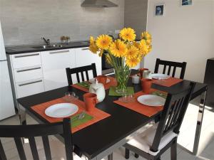 una mesa negra con flores amarillas en una cocina en SweetHomeToledo, en Nápoles