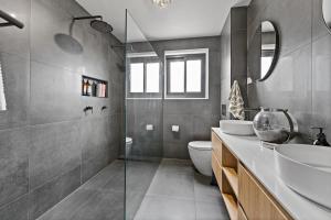a bathroom with a toilet and a sink and a mirror at 3 Bed Fully Renovated with Outdoor Fun in Watson +24 photos