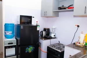 a kitchen with a black refrigerator and a microwave at Syn Homes in Nairobi