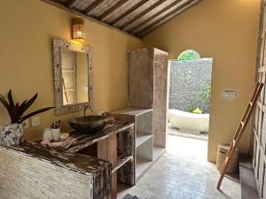 a bathroom with a sink and a mirror and a tub at Villa Lola Gili Trawangan in Gili Trawangan +15 photos
