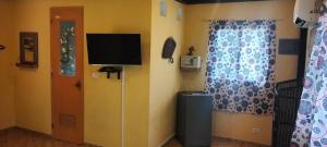 a room with a door and a television and a window at Buenaventura Beachresort in Nauhang