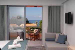 a bedroom with a bed and a couch and a balcony at Remetzo Village in Lixouri