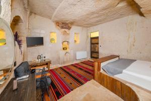 a bedroom with a bed and a desk and a tv at Angel View Suites in Göreme