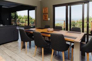 a dining room with a wooden table and chairs at Forest Hill Wilderness in Wilderness