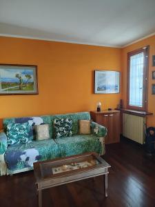 a living room with a green couch and orange walls at B&B Signora Minù in Perugia