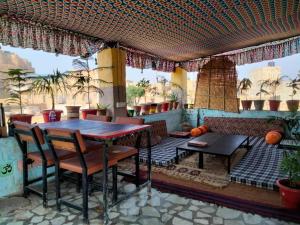 a patio with a table and chairs and a couch at Jimmy's Guest House &cafe in Jaisalmer