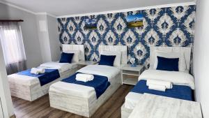 three beds in a room with blue wallpaper at Byurakan Guesthouse & Cottage in Byurakan