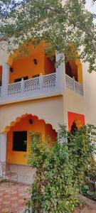 an orange and white building with a balcony at Morbagh Eco Haveli in Mandāwa +23 photos