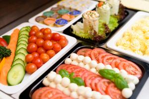 un buffet de différents types de légumes dans des plateaux dans l'établissement Tagungszentrum Neuendettelsau, à Neuendettelsau