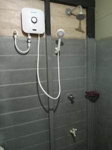 y baño con ducha y cabezal de ducha. en Hiriketiya Budget Stay, en Hiriketiya