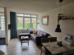 a living room with a couch and a table at De Groede in Oosterend