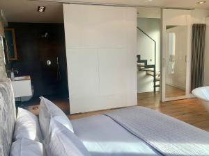 a bedroom with a bed and a bathroom with a sink at Romantic & Private Lake Como village house in Pognana Lario +16 photos