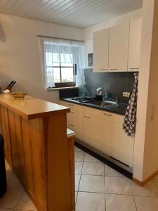 eine Küche mit weißen Schränken und einer Spüle in der Unterkunft Birke 6 in Todtmoos