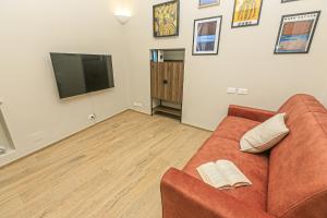 een woonkamer met een bank en een flatscreen-tv bij Dimora dell'Opera Genova centro in Genua