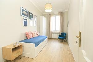 een slaapkamer met een bed met blauwe lakens en een stoel bij Dimora dell'Opera Genova centro in Genua