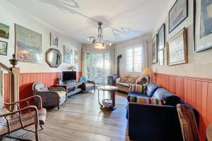 a living room with a couch and chairs and a tv at La Bade - Maison d'artiste proche des pontons in Peyriac-de-Mer