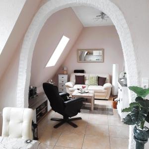 a living room with an archway with a couch and a chair at Ferienwohnungen/Ferienzimmer Seidel in Zingst