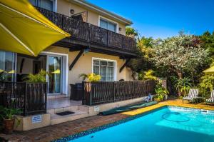 a house with a swimming pool in front of a house at Amakhaya Lodge in Cape Town