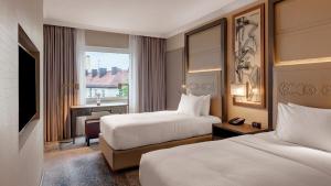 a hotel room with two beds and a window at Hilton Munich City in Munich +37 photos