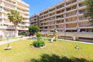 ein Park vor einem großen Wohnhaus in der Unterkunft Catalonia Park Apartamentos in Salou