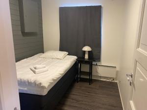 a small bedroom with a bed and a night stand at Arctic Seafront apartment in Kirkenes