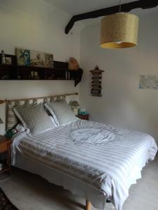 a bedroom with a bed with a blue comforter at La Chaumière en Bellevue in Muzillac