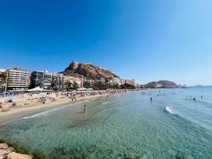 アリカンテにあるPlaya Dos Avenidasの水中の人々のいる浜