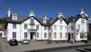 a white house with two windows and two cars parked in front of it at Burnett Arms Hotel in Banchory