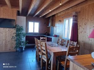 eine Küche und ein Esszimmer mit Tisch und Stühlen in der Unterkunft Chalet Chez Picou in La Tour-dʼAuvergne