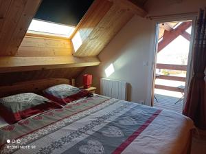 ein Schlafzimmer mit einem Bett mit Holzdecke in der Unterkunft Chalet Chez Picou in La Tour-dʼAuvergne