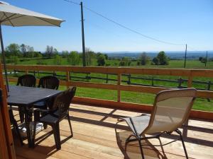 einen Tisch und Stühle auf einer Terrasse mit Aussicht in der Unterkunft Chalet Chez Picou in La Tour-dʼAuvergne