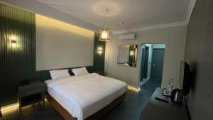 a hotel room with a bed and a television at Tangiers Hotel Yalikavak in Bodrum City