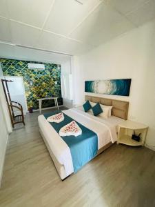 a bedroom with a large bed and a painting on the wall at Blue Maalu Resort in Ambalangoda