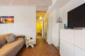 a living room with a couch and a flat screen tv at La casa di Elvira2 in Castelnuovo Berardenga