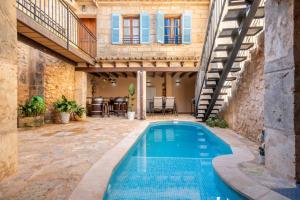 a swimming pool in a courtyard with a house at Cas Mercader in Algaida