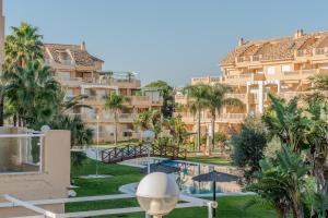 Una vista de un edificio con piscina y palmeras. en Vista Blava, en Denia