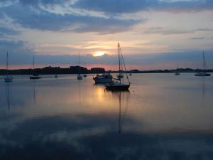a group of boats sitting in the water at sunset at Ferienwohnung mit Balkon und Schleiblick in Maasholm