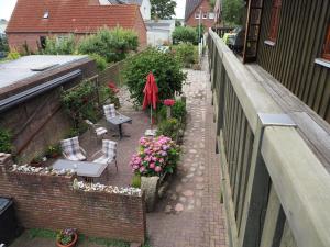 an outdoor patio with chairs and flowers on a building at Ferienwohnung mit Balkon und Schleiblick in Maasholm
