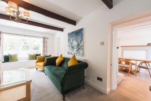 a living room with a green couch and a table at Two Trees, by Birch Stays in Hetton