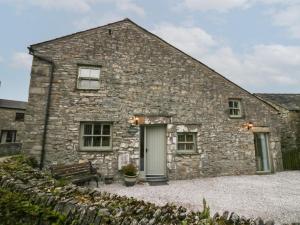 a stone house with a bench in front of it at Lady Barn in Grange Over Sands