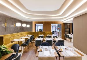 a restaurant with tables and chairs and a ceiling at Barceló Emperatriz in Madrid
