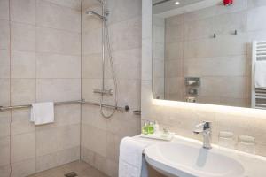 a bathroom with a shower and a sink at NH Hannover in Hannover +16 photos